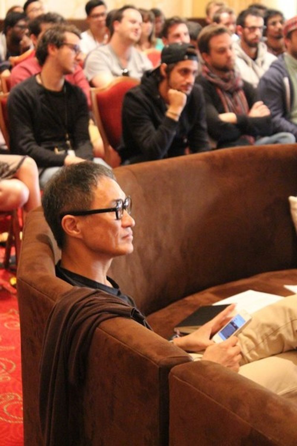 Naoki Ito in the judging room, while a group of young creatives sit in on statue discussions