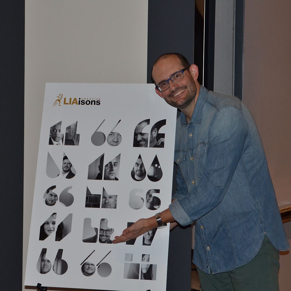 Chris Smith next to the poster of speakers